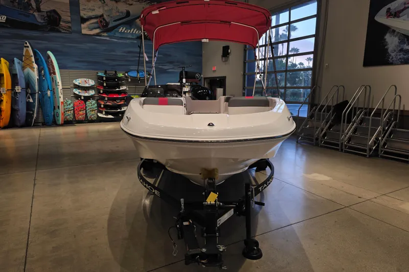Slide: The Image of 2026 Tahoe T16 boat displayed indoors with vibrant surfboards in the background. - 1