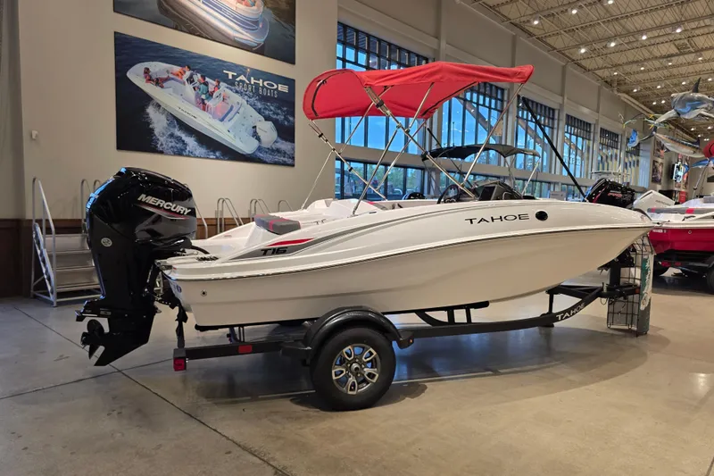 The Image of 2026 Tahoe T16 boat with red canopy and Mercury engine on display indoors. - 0