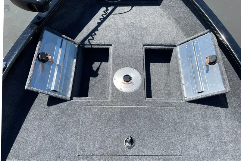Slide: The Image of 2026 Tracker Super Guide V-16 T boat deck with storage compartments and carpeted surface. - 8