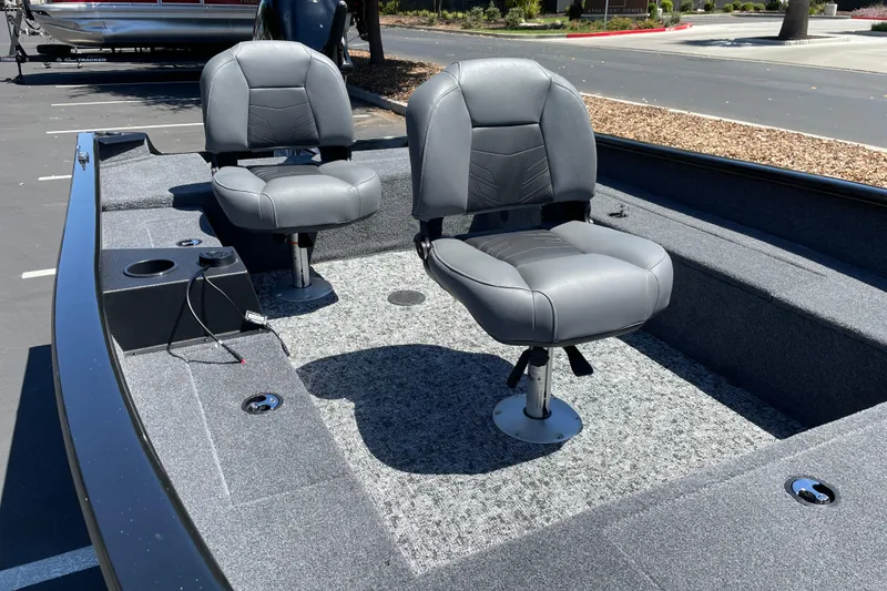 Slide: The Image of 2026 Tracker Super Guide V-16 T boat interior with two gray seats on a sunny day. - 6