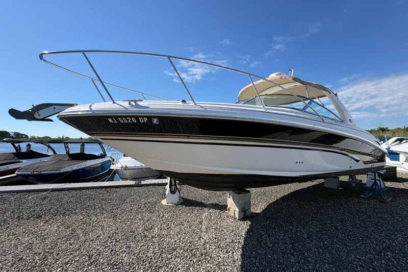 Slide: The Image of 2001 Sea Ray 290 Sun Sport boat on dry dock under clear blue sky. - 2