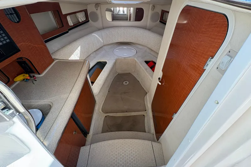 Slide: The Image of 2001 Sea Ray 290 Sun Sport cabin interior with wood accents and compact layout. - 15