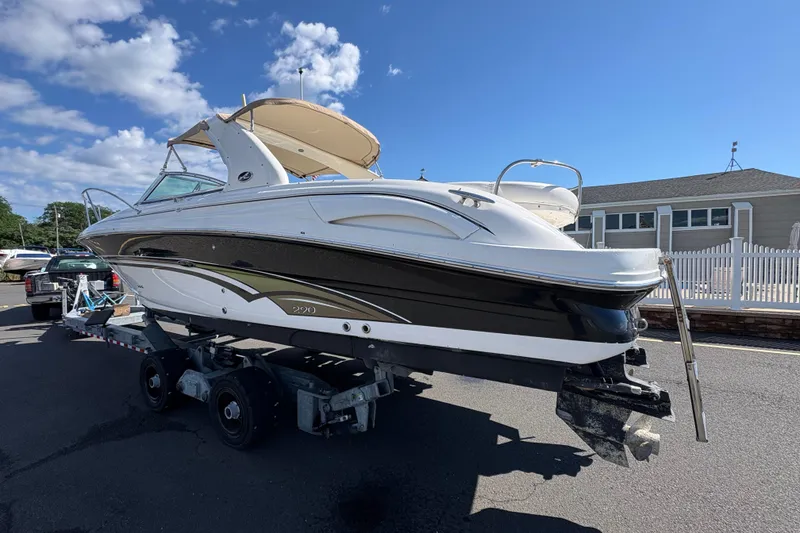 Slide: The Image of 2001 Sea Ray 290 Sun Sport boat on trailer under clear blue sky. - 8