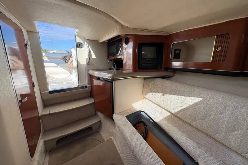 Slide: The Image of Interior of 2001 Sea Ray 290 Sun Sport boat with kitchenette and seating area. - 16