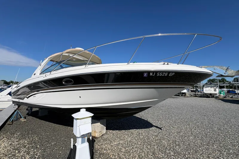 Slide: The Image of 2001 Sea Ray 290 Sun Sport boat on gravel lot under clear blue sky. - 5