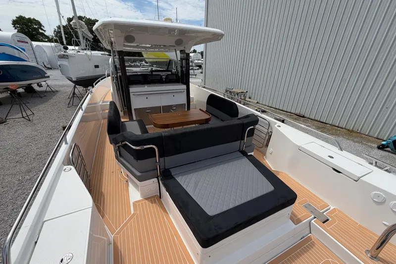 Slide: The Image of 2025 Nimbus Tender 11 boat with sleek seating and modern design in a marina setting. - 2