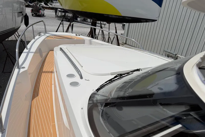 Slide: The Image of 2025 Nimbus Tender 11 boat with sleek design and spacious deck, docked outdoors. - 26