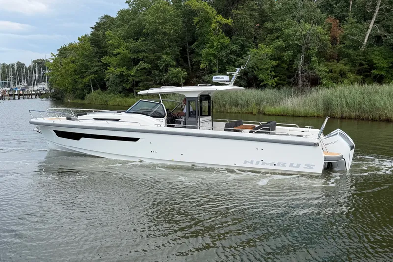 Slide: The Image of 2025 Nimbus Tender 11 boat cruising on a serene river with lush greenery. - 1