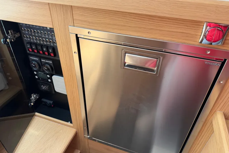 Slide: The Image of Control panel and stainless steel fridge in 2025 Nimbus Tender 11 boat interior. - 37