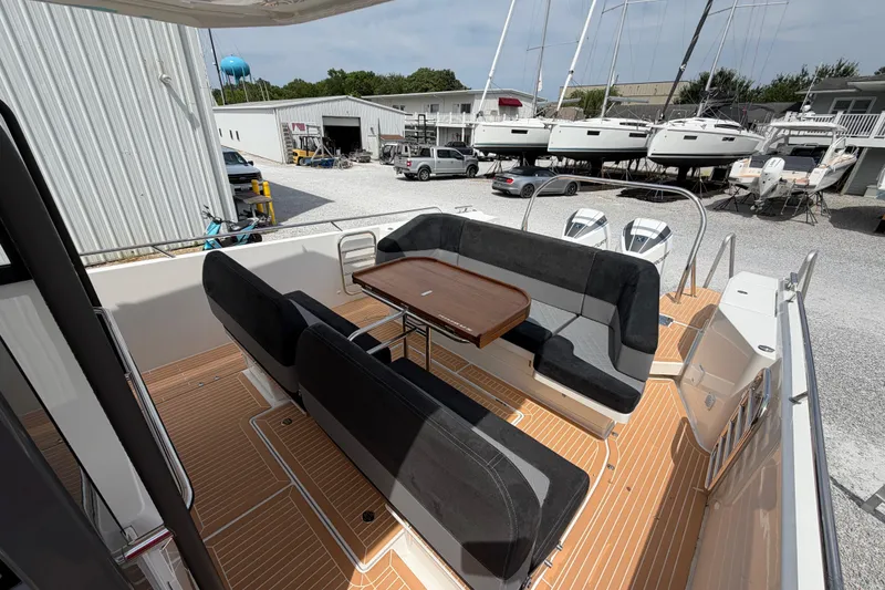 Slide: The Image of Spacious deck of 2025 Nimbus Tender 11 with seating and table, docked near boats. - 4