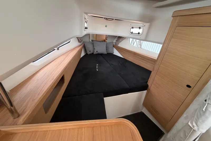 Slide: The Image of Luxurious interior cabin of 2025 Nimbus Tender 11 with sleek wood finish and cozy bedding. - 7