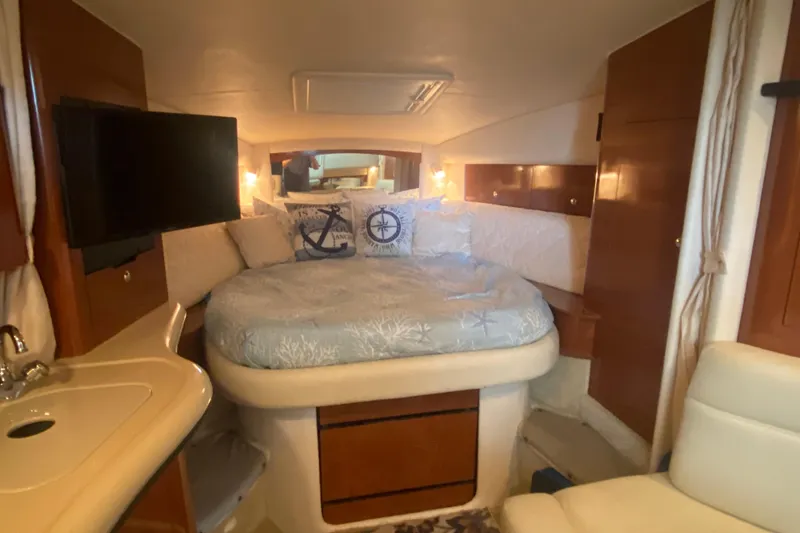 Slide: The Image of Interior of 2003 Sea Ray Sundancer 320 with cozy bed, TV, and nautical decor. - 13