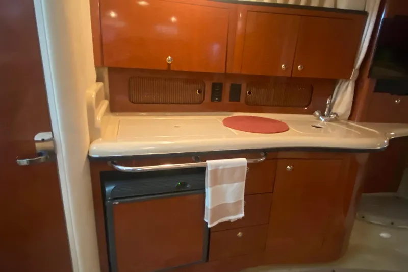 Slide: The Image of 2003 Sea Ray Sundancer 320 yacht interior kitchen with wooden cabinets and countertop. - 14