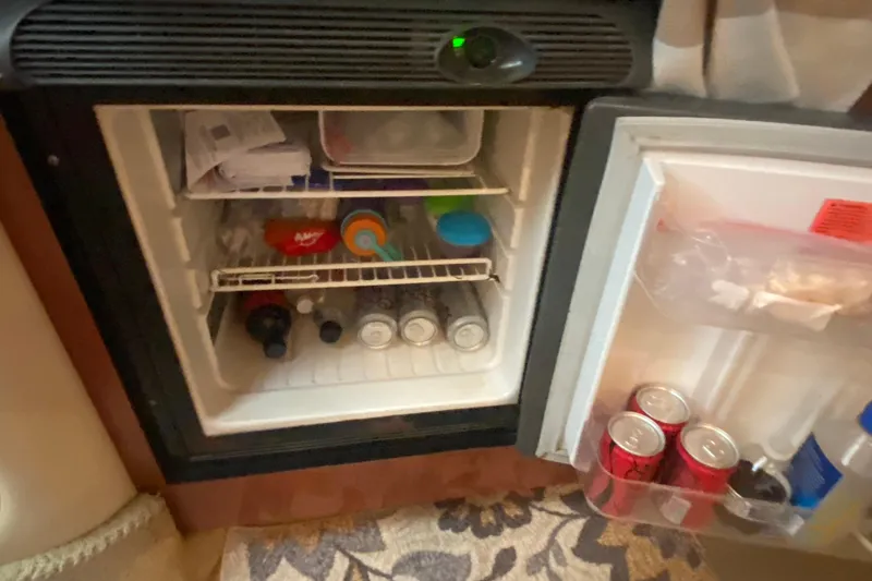Slide: The Image of Mini fridge stocked with drinks and snacks inside a 2003 Sea Ray Sundancer 320 boat. - 15