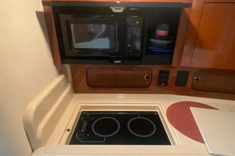Slide: The Image of Compact kitchen area in a 2003 Sea Ray Sundancer 320 yacht with stove and microwave. - 16