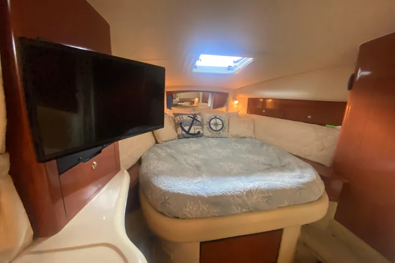 Slide: The Image of Cozy cabin interior of 2003 Sea Ray Sundancer 320 with bed and TV. - 18