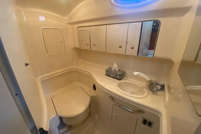 Slide: The Image of 2003 Sea Ray Sundancer 320 bathroom with toilet, sink, and storage cabinets. - 20