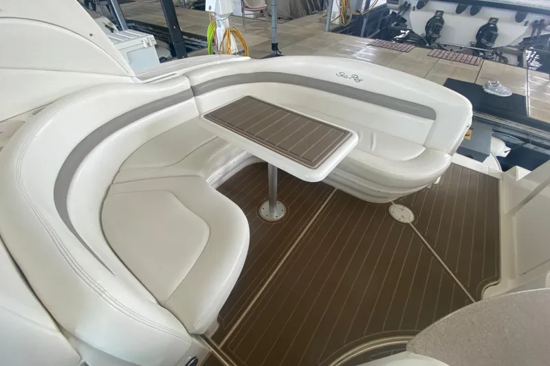 Slide: The Image of 2003 Sea Ray Sundancer 320 interior with curved seating and wooden table. - 27