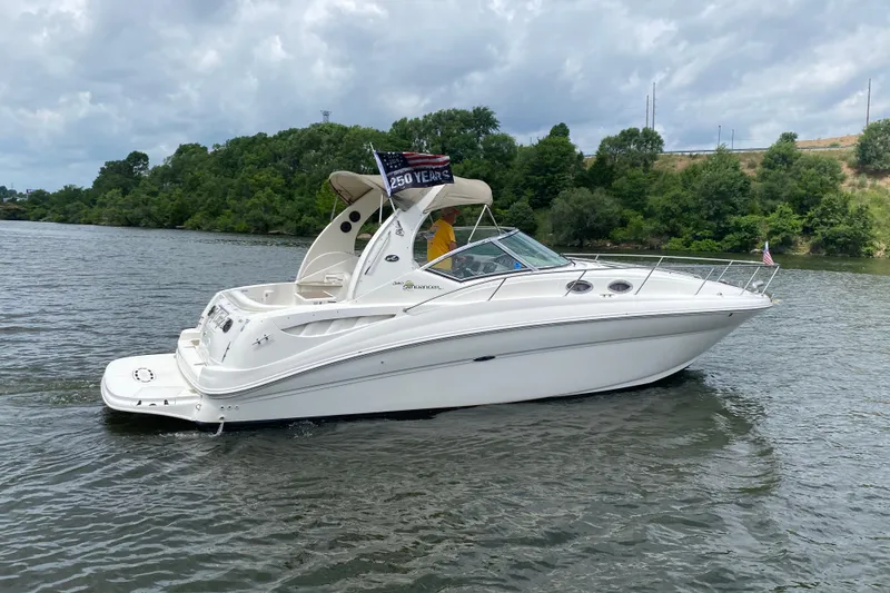 Slide: The Image of 2003 Sea Ray Sundancer 320 cruising on a scenic river with lush greenery. - 3