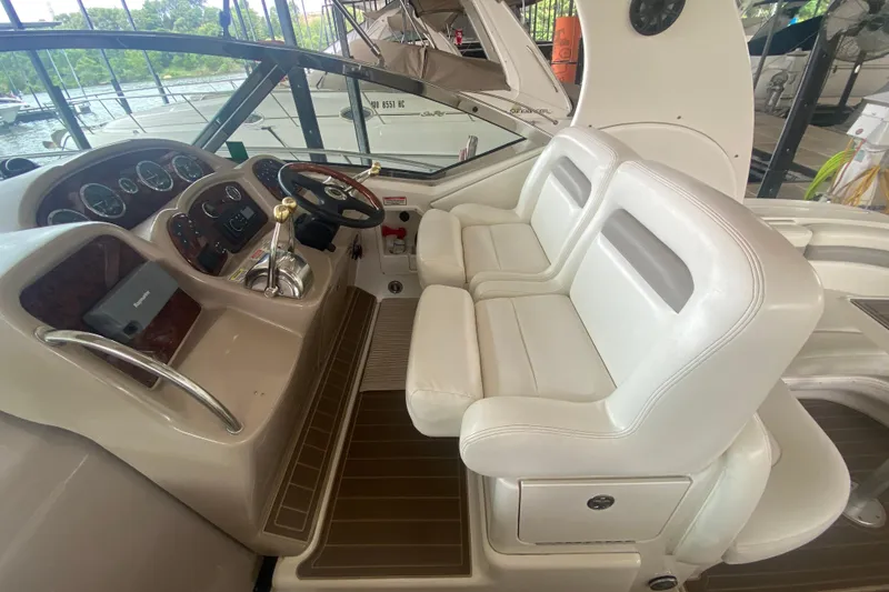Slide: The Image of 2003 Sea Ray Sundancer 320 cockpit with dual white leather seats and control panel. - 30