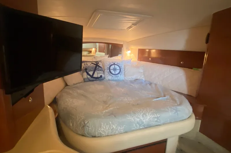 Slide: The Image of Cozy cabin interior of 2003 Sea Ray Sundancer 320 with bed, pillows, and TV. - 34