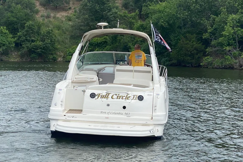 Slide: The Image of 2003 Sea Ray Sundancer 320 boat on a lake, surrounded by lush greenery. - 4