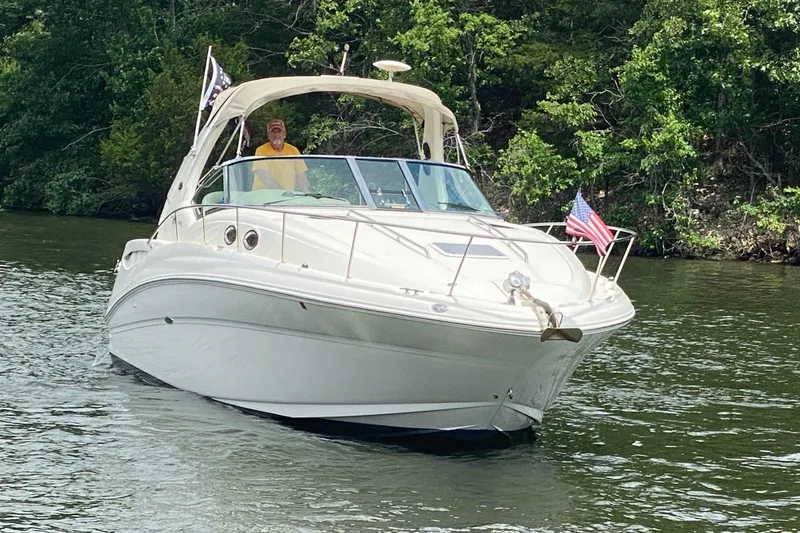 Slide: The Image of 2003 Sea Ray Sundancer 320 cruising on a scenic lake with lush green trees. - 6