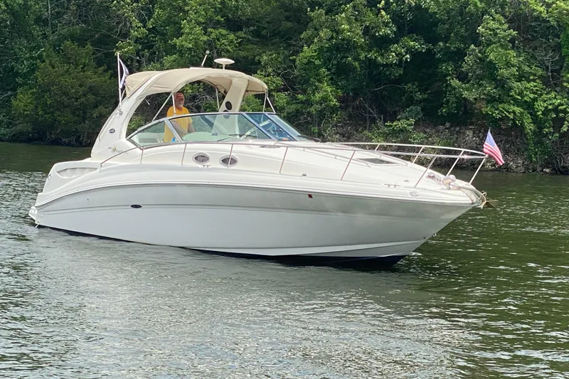 Slide: The Image of 2003 Sea Ray Sundancer 320 cruising on a lake with lush green trees in the background. - 7