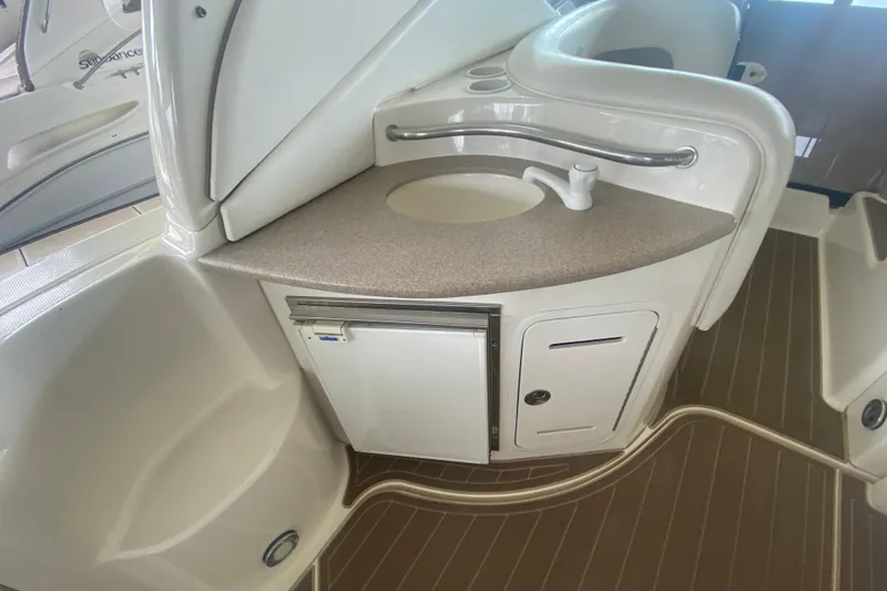 Slide: The Image of 2003 Sea Ray Sundancer 320 interior with sink and mini fridge in cabin area. - 9