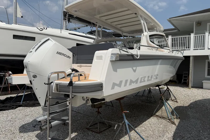 Slide: The Image of 2025 Nimbus Weekender 9 boat with Mercury engine, elevated on stands in a marina. - 1