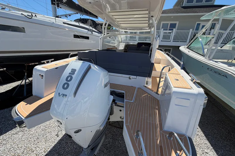 Slide: The Image of 2025 Nimbus Weekender 9 boat with Mercury 300 V8 engine, docked outdoors. - 2