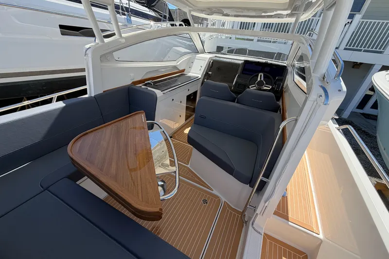 Slide: The Image of Interior of 2025 Nimbus Weekender 9 boat with sleek seating and wooden table. - 3
