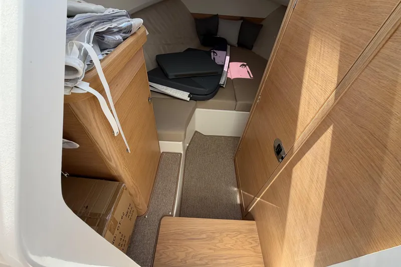 Slide: The Image of Interior cabin of 2025 Nimbus Weekender 9 boat with wooden finish and seating area. - 6