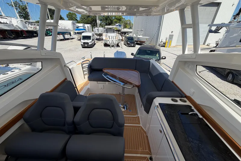 Slide: The Image of Interior of 2025 Nimbus Weekender 9 boat with seating and table, docked in a marina. - 8