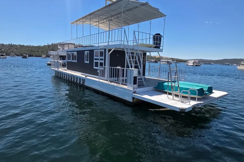 The Image of Custom 2007 houseboat on serene lake, featuring upper deck and modern design. - 0