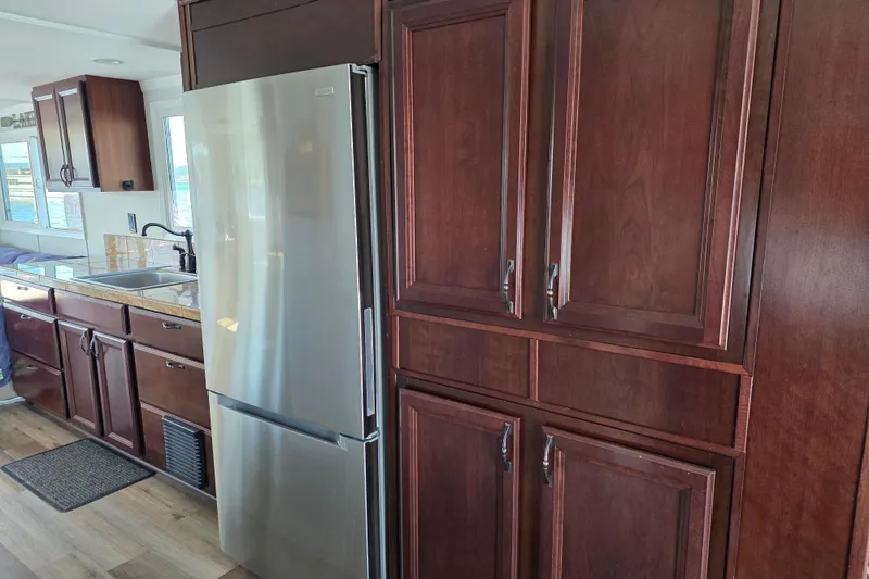 Slide: The Image of Houseboat kitchen interior with dark wood cabinets and stainless steel refrigerator, 2007 model. - 14