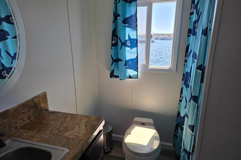 Slide: The Image of Houseboat bathroom with shark-themed curtains, window view, and modern fixtures, 2007 Custom model. - 15