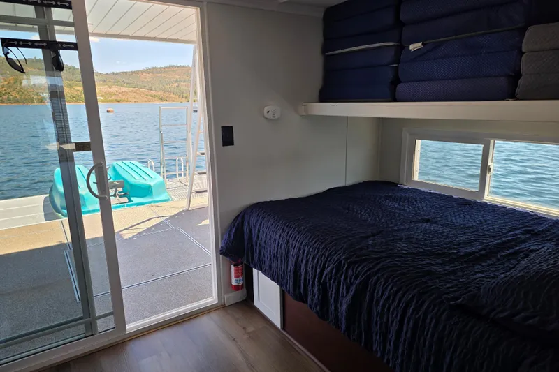 Slide: The Image of Interior of a 2007 custom houseboat with bed, lake view, and sliding glass door. - 16