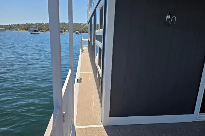Slide: The Image of Side view of a 2007 custom houseboat on a serene lake. - 4