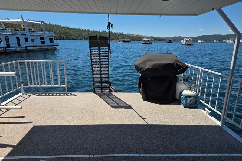 Slide: The Image of Houseboat deck with grill overlooking a scenic lake, surrounded by other boats. - 6