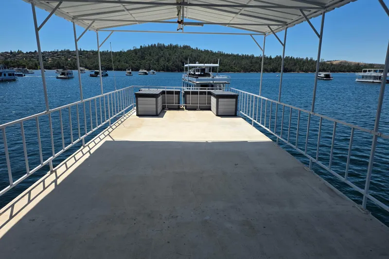 Slide: The Image of Open deck of a 2007 custom houseboat on a serene lake with distant boats. - 7