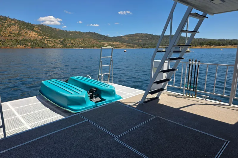 Slide: The Image of Houseboat deck with turquoise pedal boat, scenic lake view, and stairs, 2007 Custom model. - 8