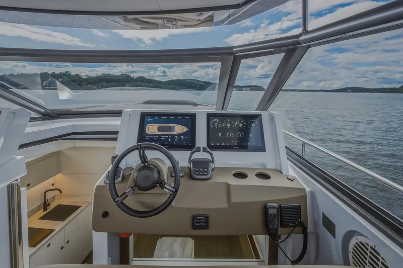 Slide: The Image of Steeler Bronson 50 yacht cockpit with modern controls, overlooking serene waters, 2022 model. - 60