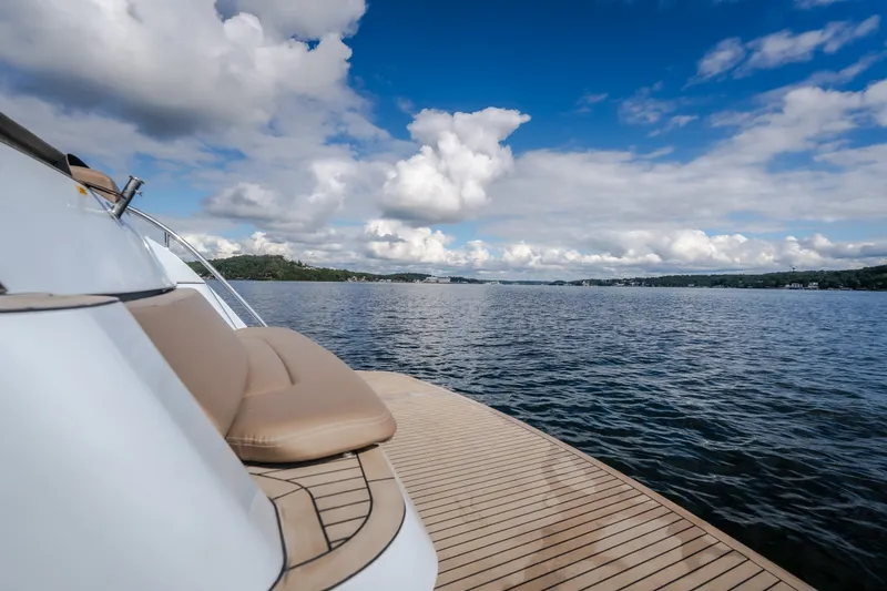 Slide: The Image of Luxurious Steeler Bronson 50 yacht deck, 2022 model, overlooking serene lake and cloudy sky. - 18