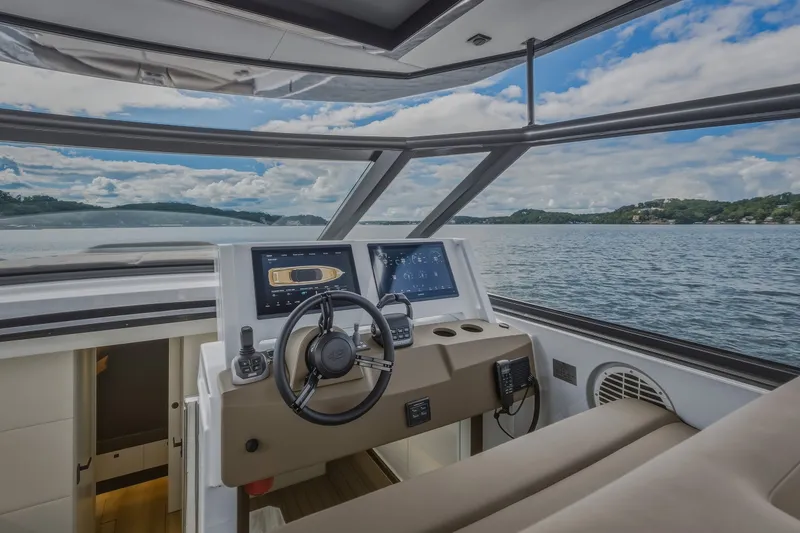 Slide: The Image of Steeler Bronson 50 yacht cockpit with modern controls, overlooking serene lake view. - 59