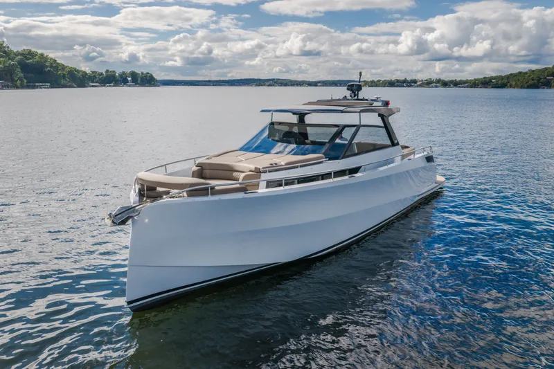Slide: The Image of 2022 Steeler Bronson 50 yacht cruising on a serene lake under a partly cloudy sky. - 5