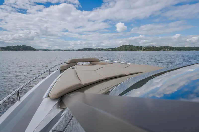 Slide: The Image of 2022 Steeler Bronson 50 yacht cruising on a serene lake under a partly cloudy sky. - 47