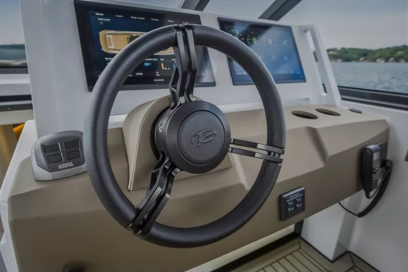Slide: The Image of Steeler Bronson 50 yacht helm, featuring modern steering wheel and digital displays, 2022 model. - 61