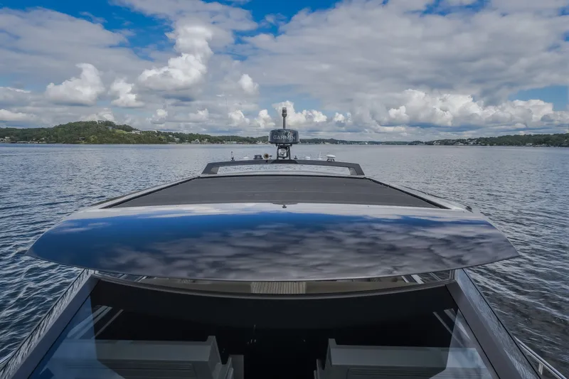 Slide: The Image of Steeler Bronson 50 yacht cruising on a serene lake under a partly cloudy sky. - 56