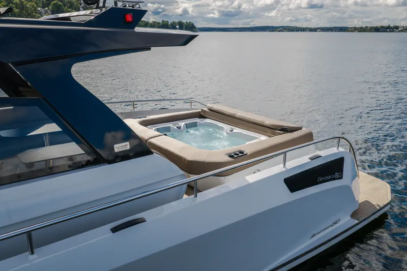 Slide: The Image of Die Steeler Bronson 50 von 2022 hat einen Whirlpool auf dem Deck und liegt auf einem ruhigen See. - 4